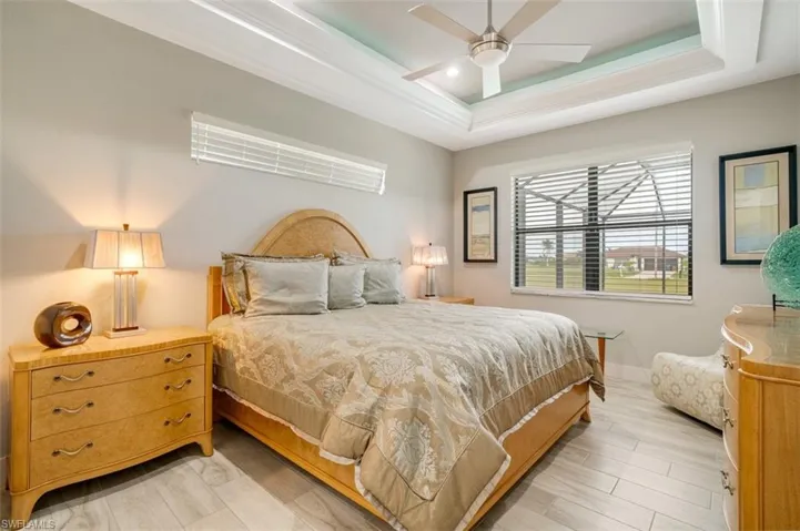 Bedroom featuring beautiful tray ceiling illuminated with lighting selection
