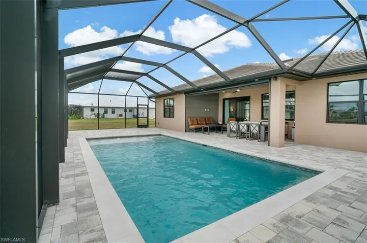 View of swimming pool with full width screened lanai