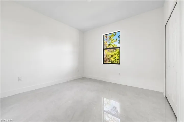 Unfurnished bedroom with a closet and light tile flooring