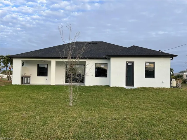 Rear view of house featuring a lawn