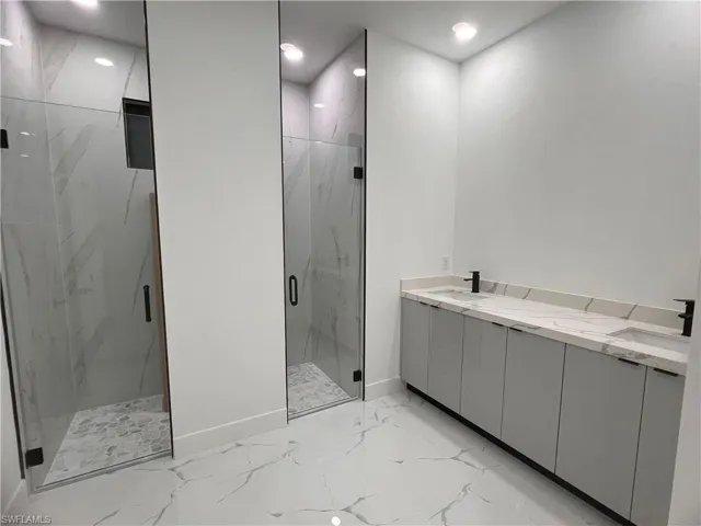 Bathroom featuring vanity and a shower with door