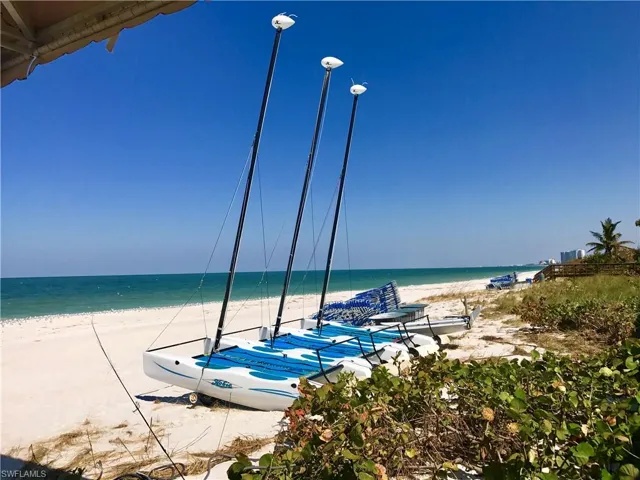 Beachfront expanse with white sand, turquoise water, and clear blue skies