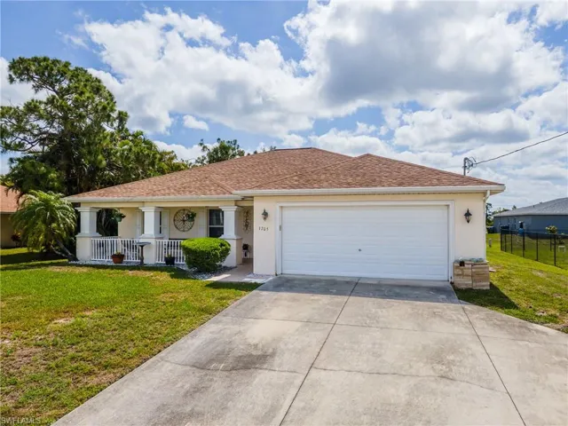 View of front of property featuring stucco siding, a porch, concrete driveway, and an attached garage