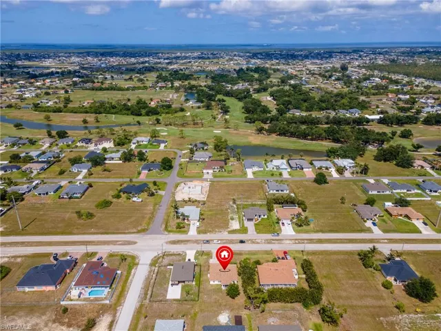 Aerial view of property's location with a nearby body of water and nearby suburban area
