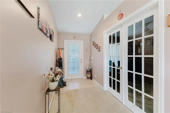 Doorway to outside featuring carpet flooring, baseboards, recessed lighting, and tile patterned flooring