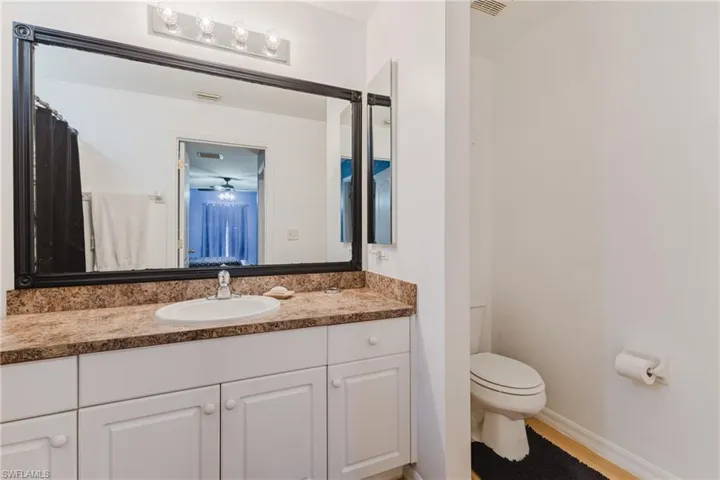 Bathroom featuring toilet, vanity, and baseboards
