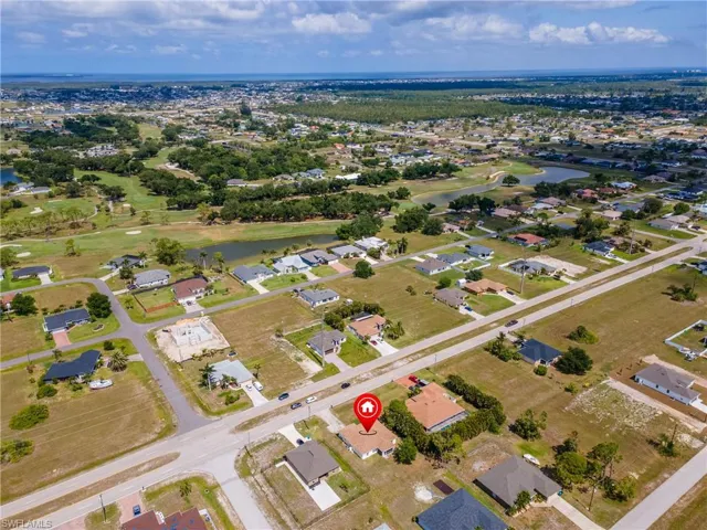Aerial overview of property's location featuring a nearby body of water and nearby suburban area