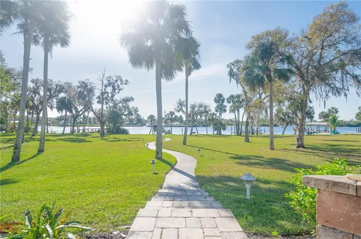 Winding Paver walkway to the river, boat dock, covered boat lift.