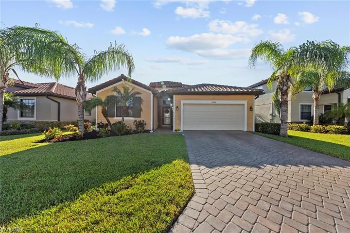 View of front facade featuring a front yard and a garage