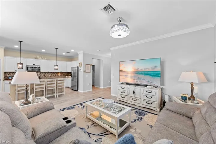Living room featuring light wood-type flooring and ornamental molding