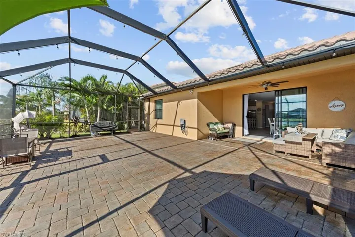 View of patio featuring outdoor lounge area, glass enclosure, and ceiling fan