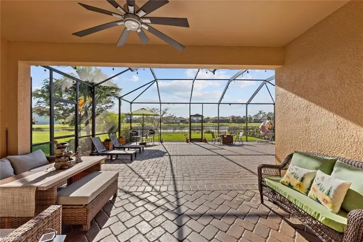 View of patio / terrace with an outdoor living space, glass enclosure, and ceiling fan