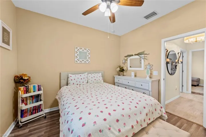 Bedroom with dark hardwood / wood-style floors and ceiling fan