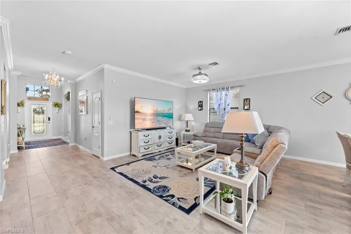 Living room with a notable chandelier and ornamental molding