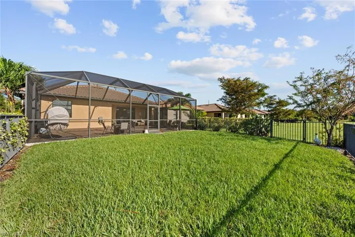 View of yard featuring glass enclosure and a patio