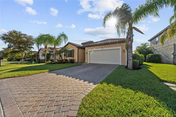 Mediterranean / spanish-style house with a garage and a front lawn
