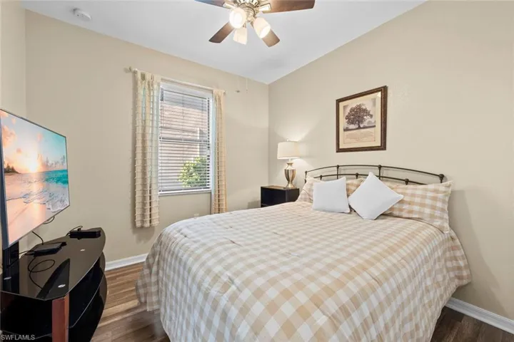 Bedroom with dark hardwood / wood-style flooring and ceiling fan