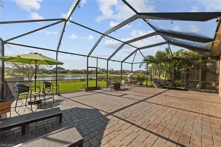 View of patio with glass enclosure and a water view