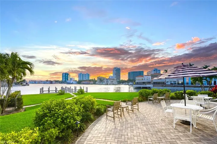 View of community with a city view, a water view, a lawn, and outdoor dining area