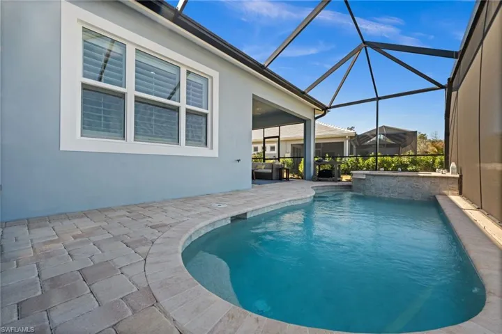 Swimming pool with a sunroom, a patio, and a lanai