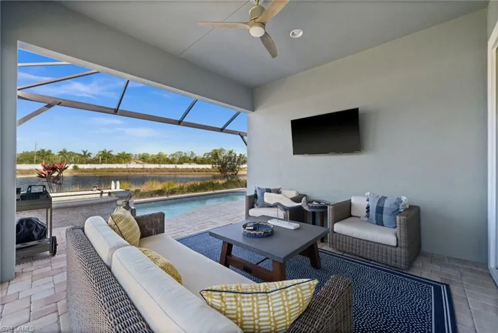 View of patio / terrace with a lanai, an outdoor pool, a sunroom, outdoor seating, and a ceiling fan