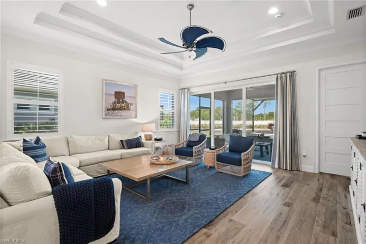 Living area with light wood-style floors and a ceiling fan
