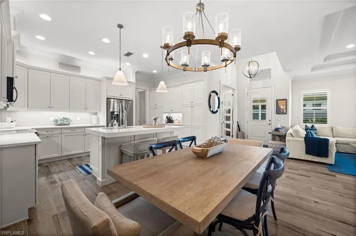 Dining room featuring crown molding, hanging lights, and dark wood-style flooring