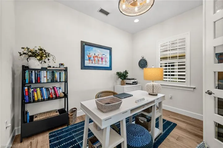 Office area with light wood-style flooring and recessed lighting