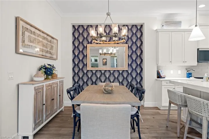 Dining room featuring a chandelier, dark wood finished floors, and ornamental molding