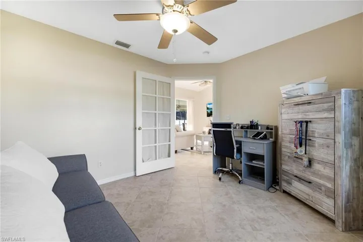 Office with light tile patterned flooring, ceiling fan, and french doors