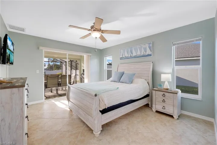 Tiled bedroom featuring access to outside and ceiling fan