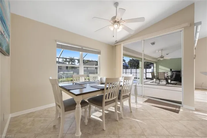 Dining room featuring light tile patterned flooring, ceiling fan, and vaulted ceiling