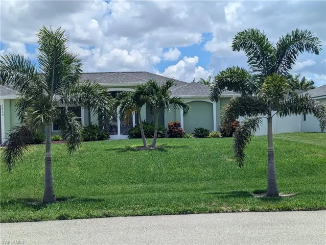 View of front of home featuring Royal Palm trees