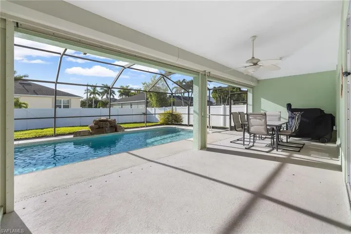 View of swimming pool with a lanai, a patio area, and ceiling fan