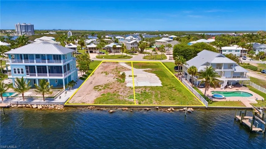 Waterfront lot featuring a partial concrete driveway and grass coverage