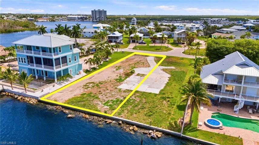 Waterfront lot featuring direct canal access, a rip-rap seawall, and clear land ready for development