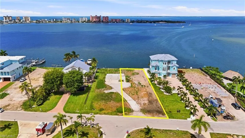 Waterfront lot with substantial water frontage, featuring an established concrete driveway and ample space for custom construction