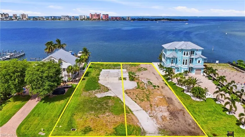 Waterfront lot featuring a concrete driveway and direct water access