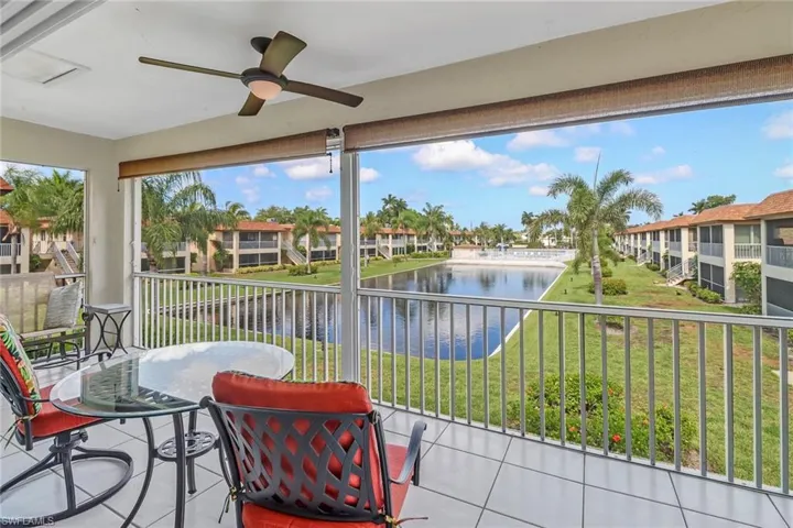 Sunroom / solarium featuring ceiling fan and a water view
