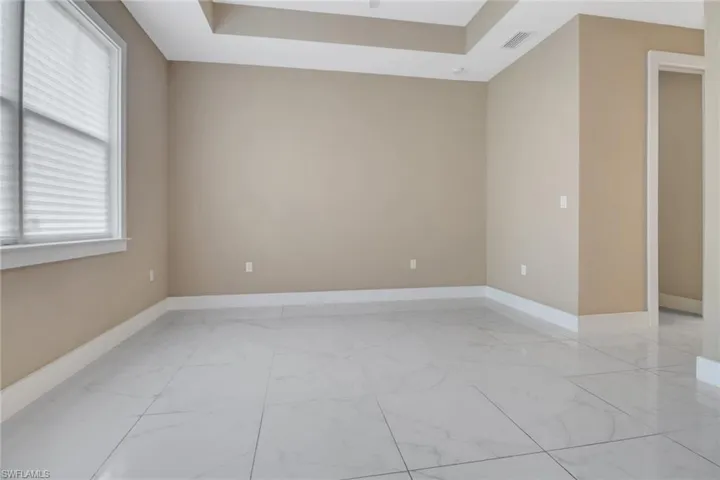 Tiled main bedroom with large windows