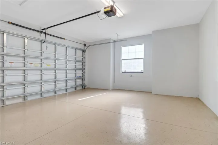 Two car garage featuring a window and automatic garage door opener