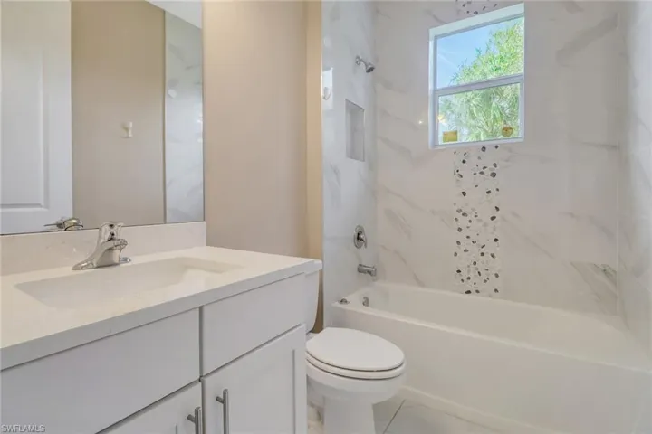 Guest bathroom featuring vanity and tiled combination tub / shower