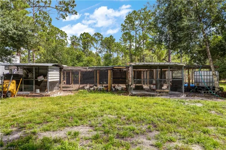 Chicken coop with chickens, featuring exterior structure, a yard,