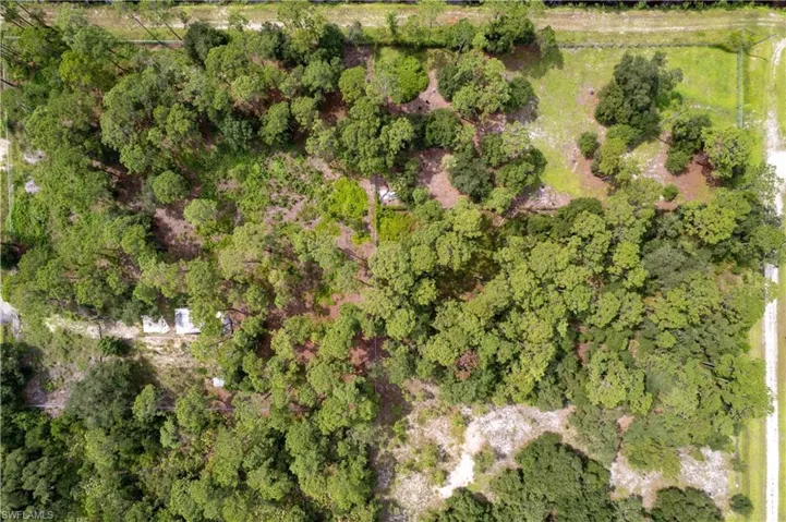 Aerial view of property and surrounding area featuring a heavily wooded area