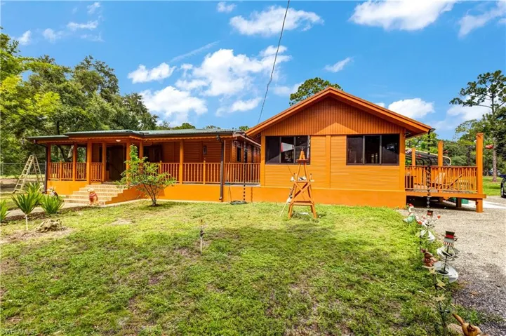 Side view of house featuring a lawn and covered porch