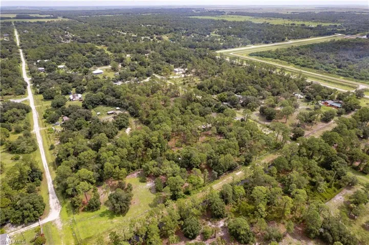 Aerial view of property's location with a heavily wooded area