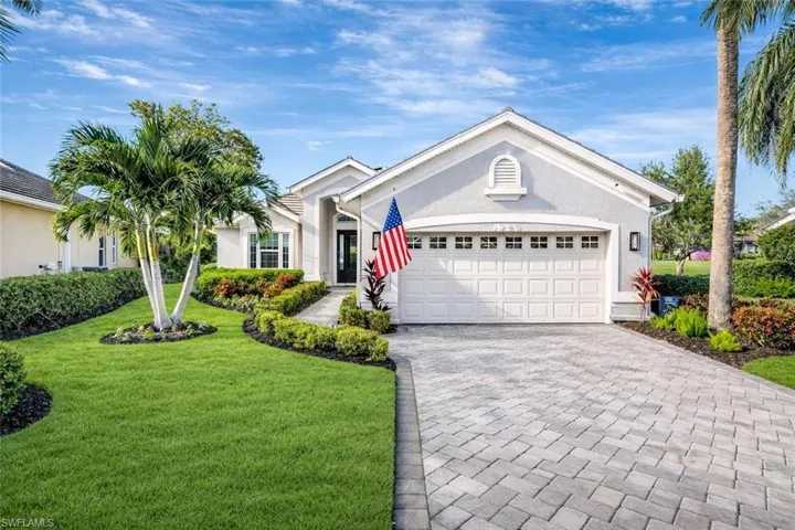 Ranch-style home featuring a front lawn, decorative driveway, an attached garage, and stucco siding