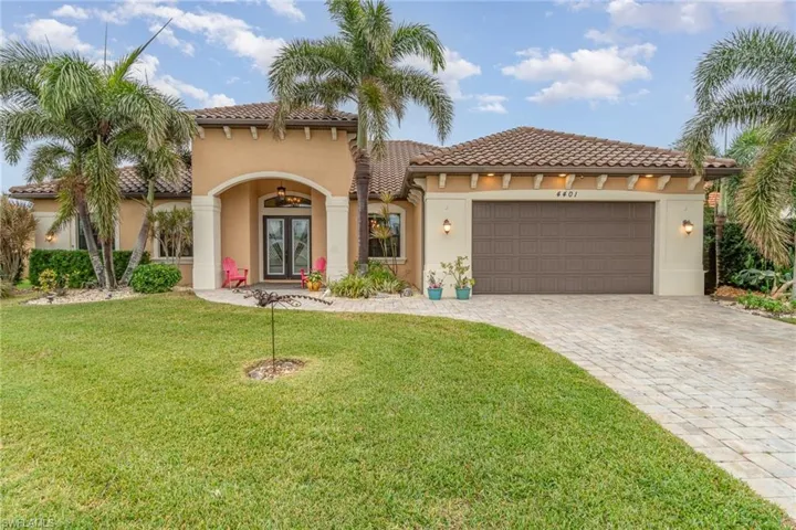 Mediterranean home with tile roof and paver drive