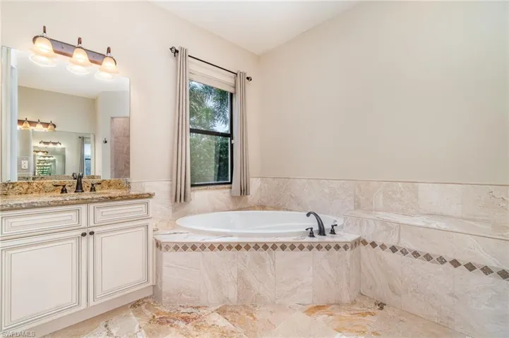 PRimary Bathroom 1 featuring tiled tub and vanity