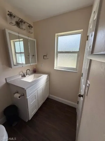 Bathroom featuring hardwood / wood-style floors, vanity, and toilet